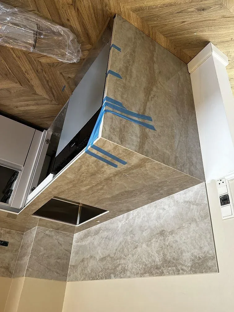 Köksbänkskiva i polerad Dekton Arga med urtag för häll och underlimmad rostfri diskho, monterad i ett kök i Valby.