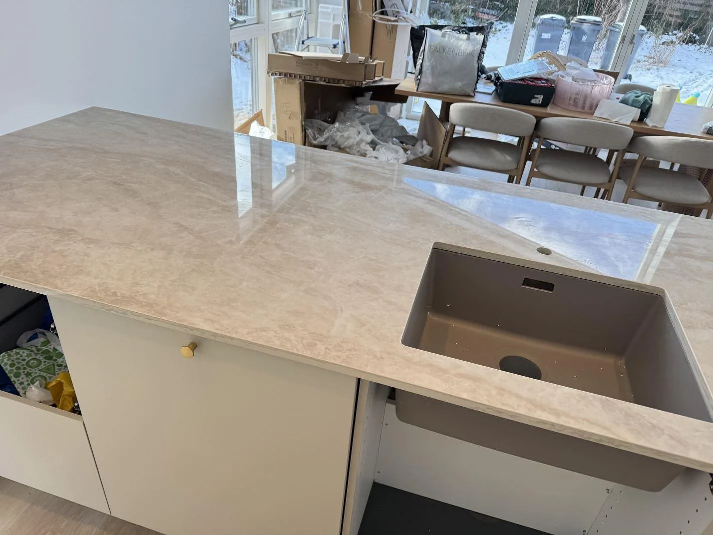 Köksbänkskiva i polerad Dekton Arga, keramik i krämbeige med mjuk ådring, på en köksö med underlimmad komposithoar i ett kök i Valby.
