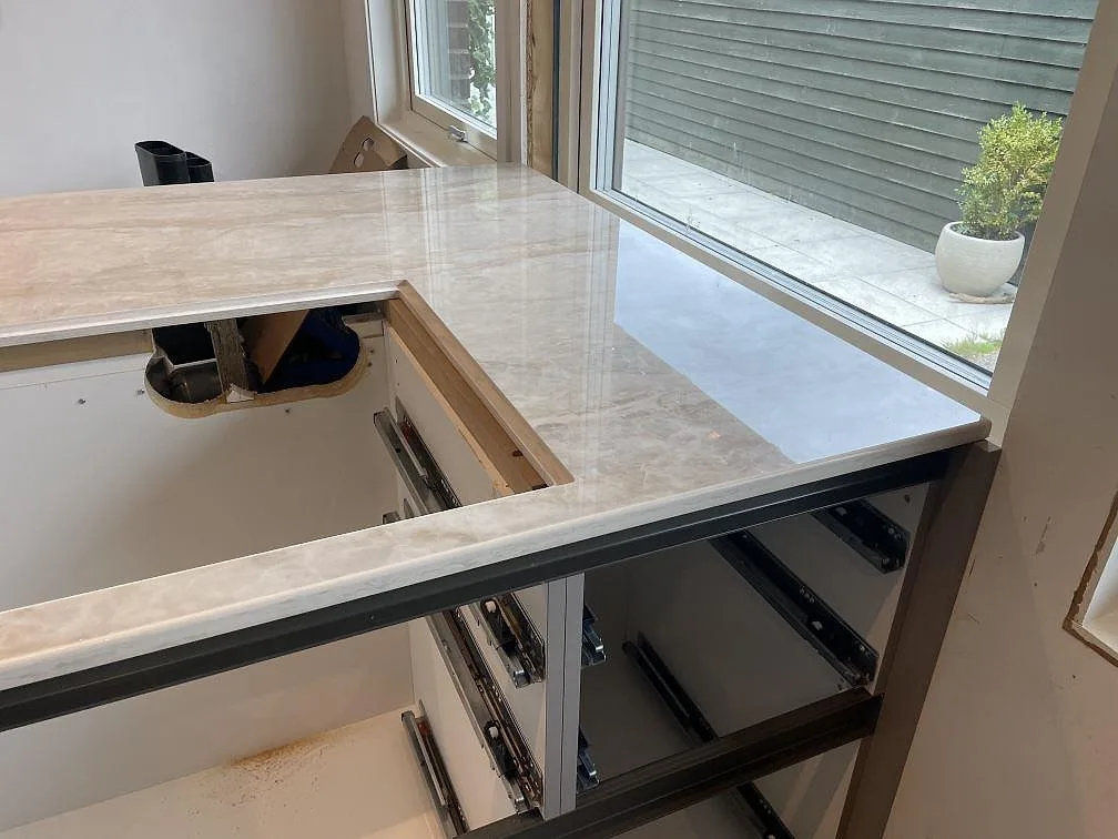 Köksbänkskiva i polerad Dekton Arga, beige keramik med blank yta och urtag vid fönster i Veberöd.