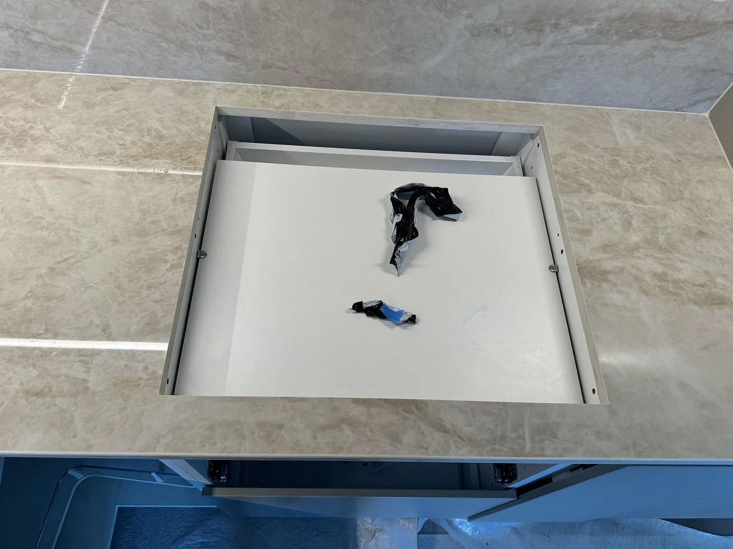 Monteringsbild av polerad Dekton Arga i Ystad, med köksbänkskiva runt en öppen utskärning och stänkskydd bakom.