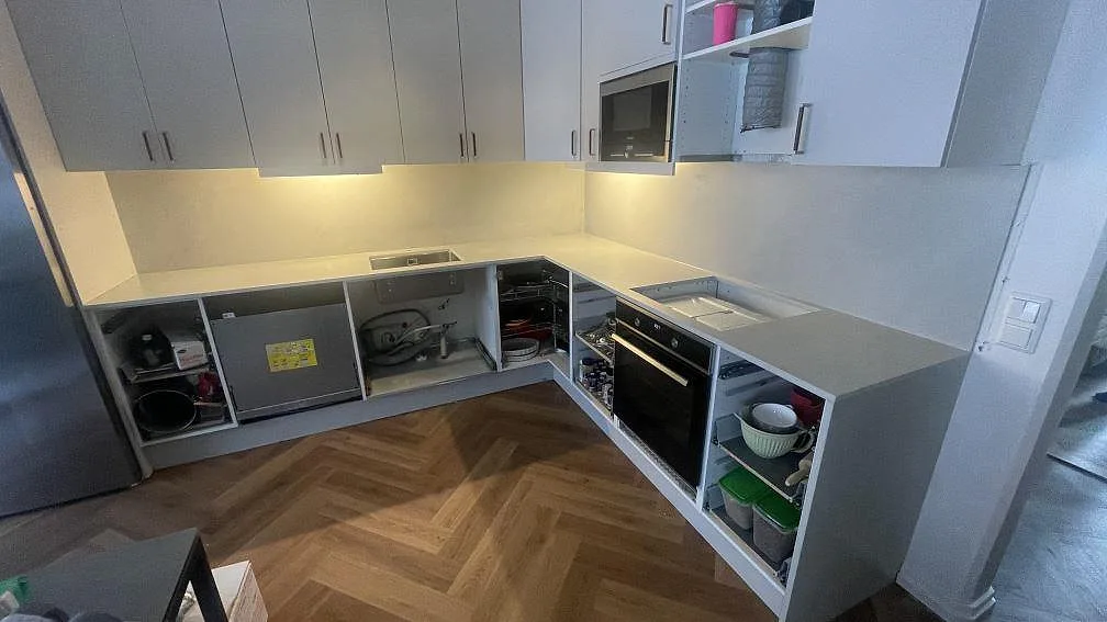 L-format kök i Lund med matt keramikbänkskiva i Dekton Argentium och matchande stänkskydd under montering.