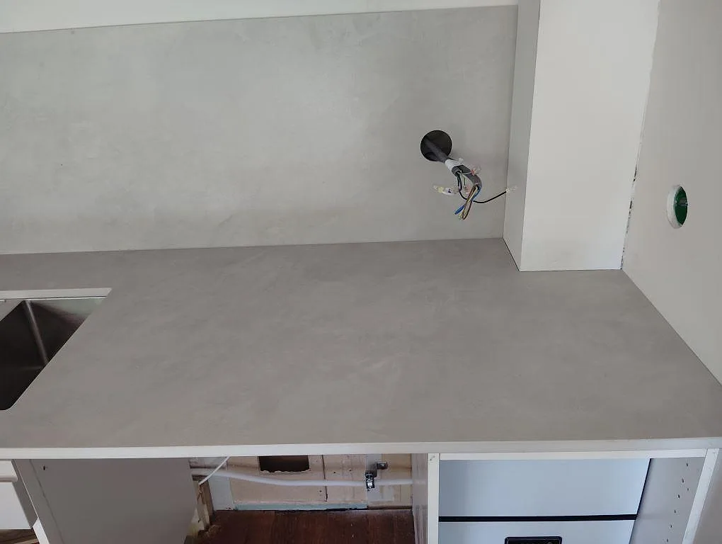 Installerad köksbänkskiva i grå matt Dekton Argentium med öppna köksstommar och väggbeklädnad i Sollentuna.