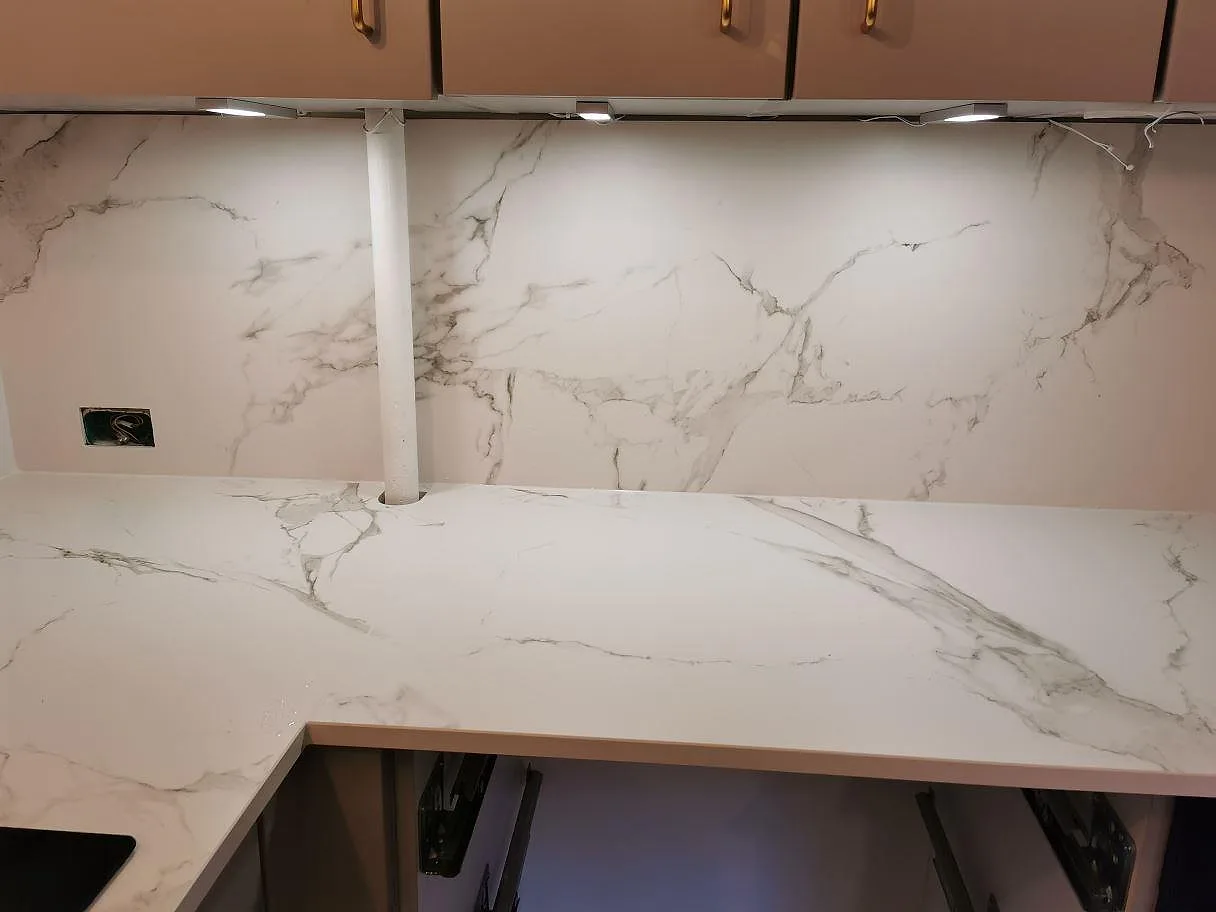 Vinklad köksbänkskiva i Dekton Aura 15 med heltäckande stänkbeklädnad och tydlig grå ådring i ett kök i Frederiksberg C.