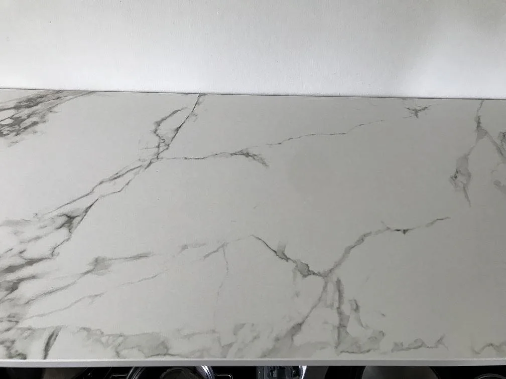 Närbild på den marmorlika ådringen i vit Dekton Aura 15, matt keramisk bänkskiva i ett kök i Ølstykke.