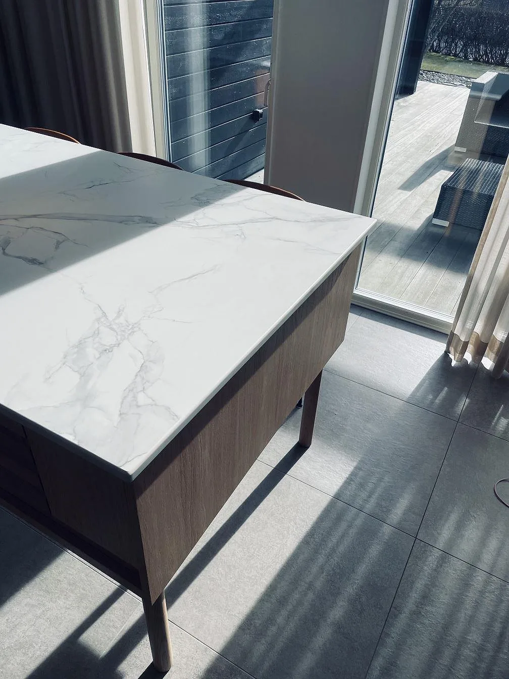 Närbild på ådringen i Dekton Aura 22, matt vit keramik med grå marmorliknande ådring, på köksön i ett kök i Falkenberg.