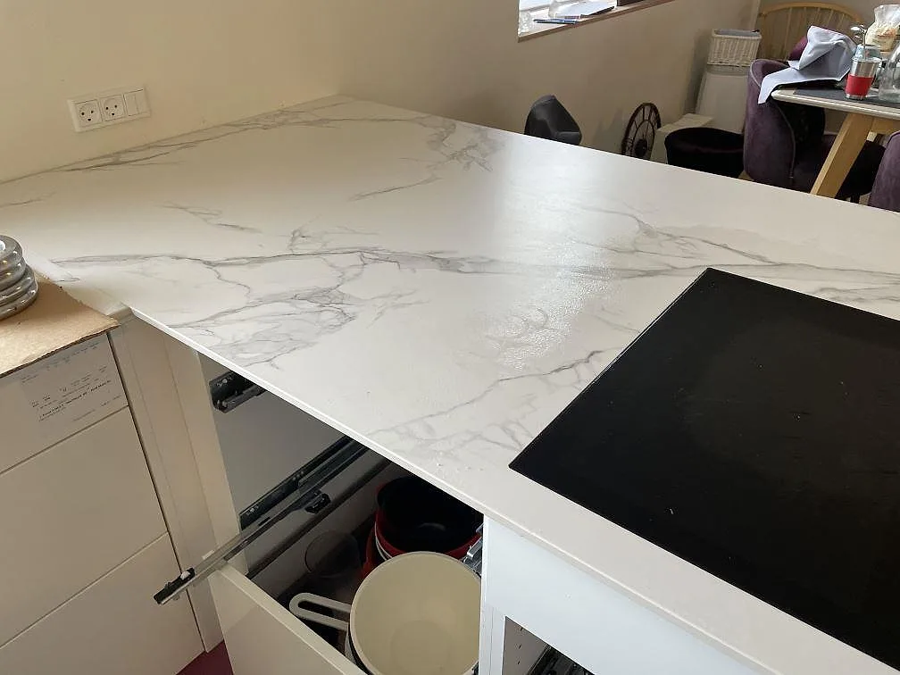 Detalj av matt Dekton Aura 22 bänkskiva med infälld induktionshäll och öppen köksstomme i Glostrup.