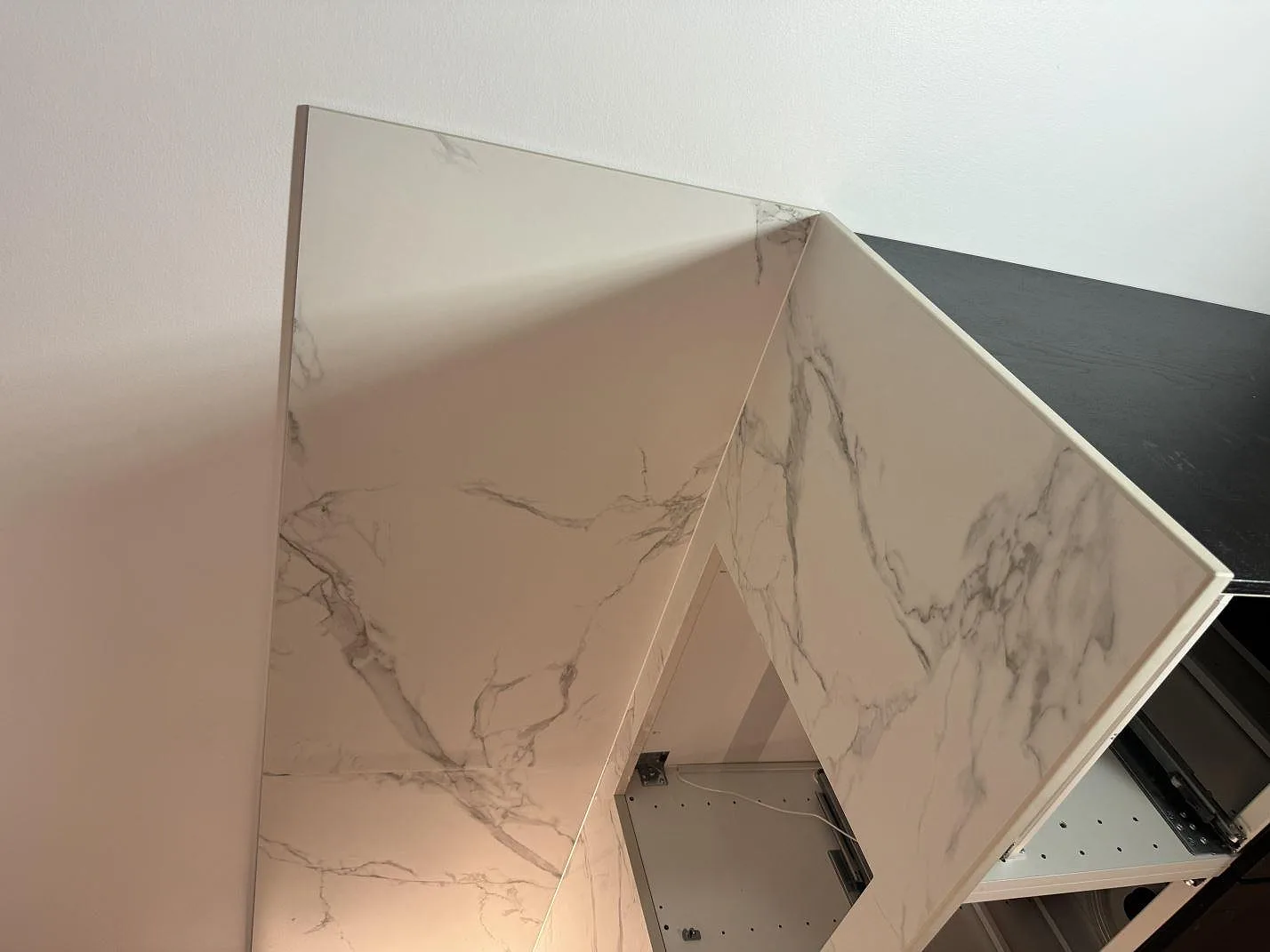 Sidovy av matt Dekton Aura 22 med bänkskiva och vertikal väggbeklädnad under montering i Malmö.