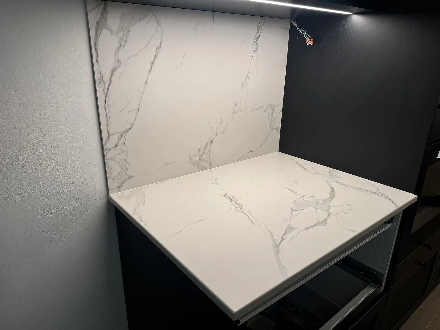 Matt köksbänkskiva i keramik, Dekton Aura 22, med hög väggbeklädnad i samma ådrade sten i Malmö.