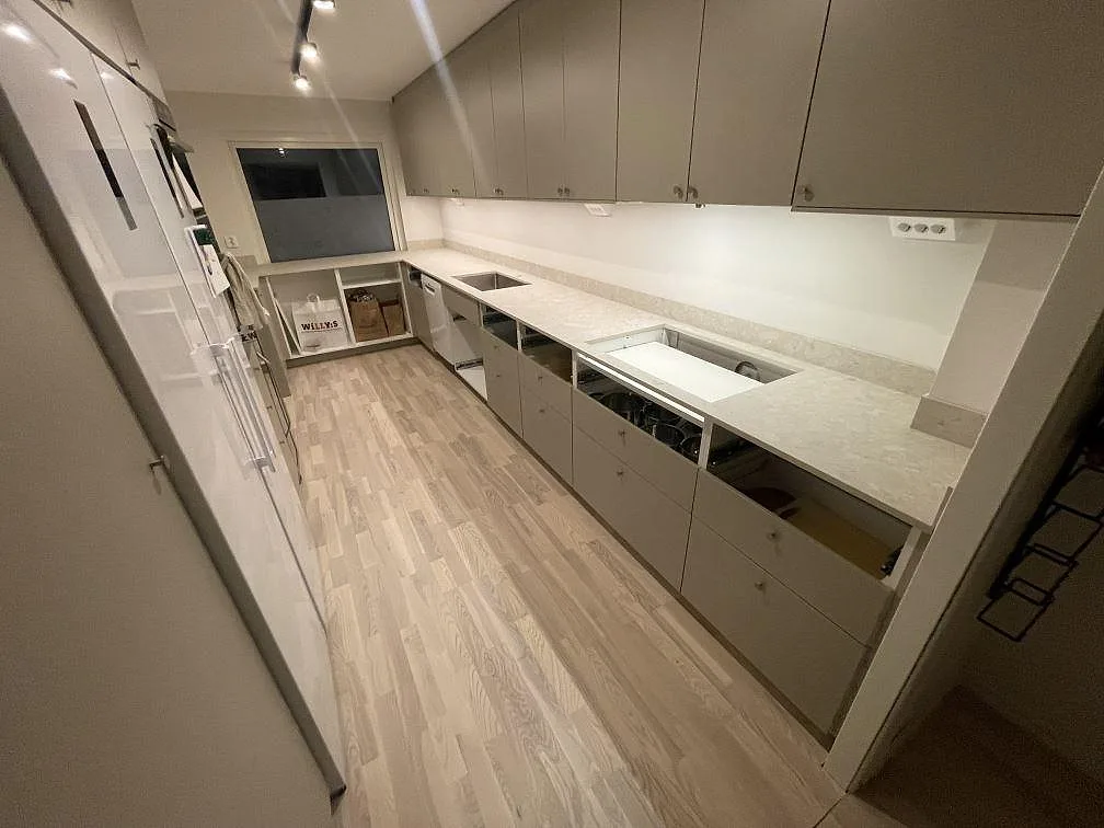 Köksbänkskiva i matt Dekton Ava, keramik, med underlimmad diskho, håltagning för häll och låg stänkkant i ett kök i Bålsta.