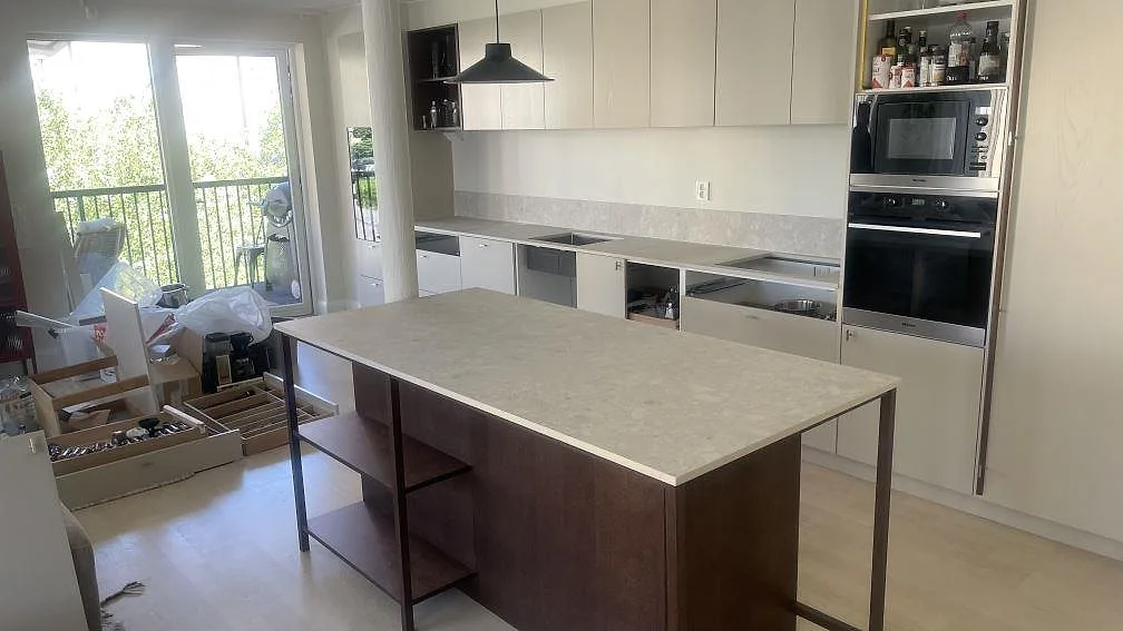 Köksbänkskiva och köksö i matt Dekton Ava med matchande låg stänkkant i ett kök i Borås.