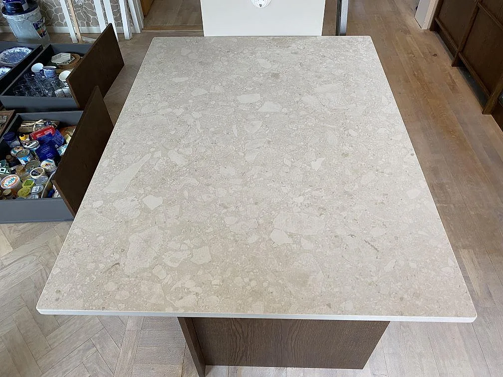 Stor köksö i matt Dekton Ava med ljus spräcklig keramikyta och rak kant i ett kök under montering i Göteborg.