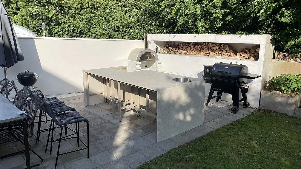 Utomhuskök i Helsinborg med bänkskiva i matt Dekton Ava, rund rostfri diskho och ljus keramisk yta på uteplatsen.