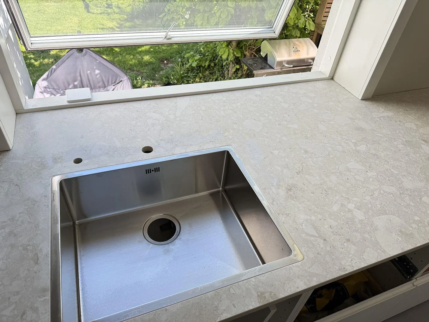 Matt Dekton Ava-bänkskiva runt fönster och diskho, med ljus mönstring under montering i Hvidovre.