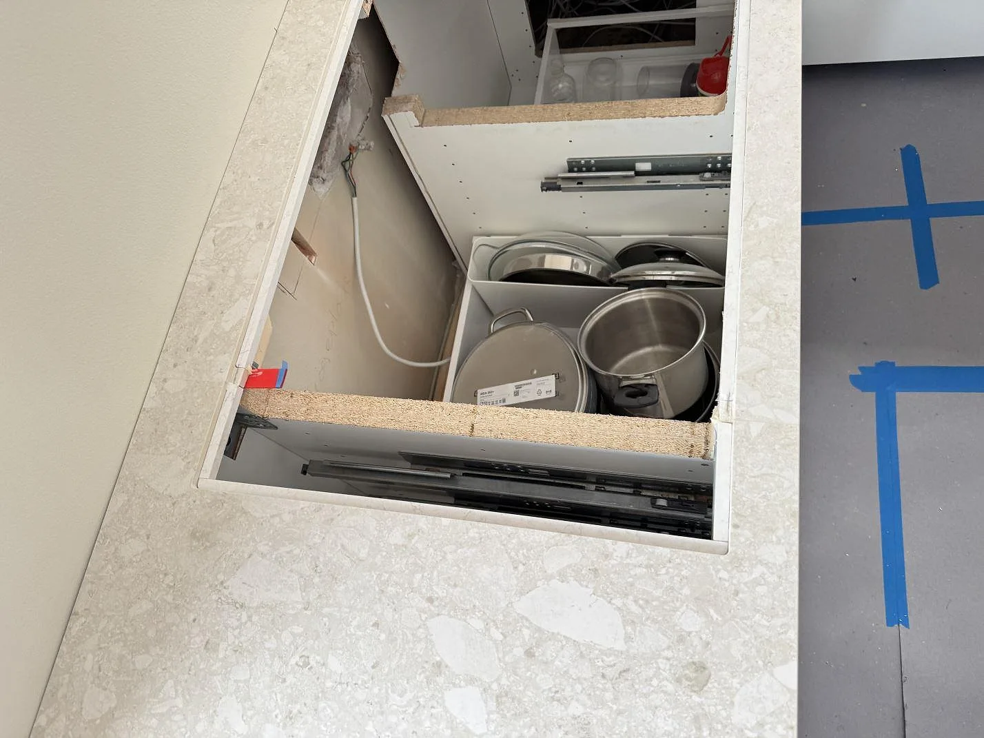Detalj av öppet urtag i matt Dekton Ava, 20 mm, med köksstommar och skyddat golv under montering i Hvidovre.