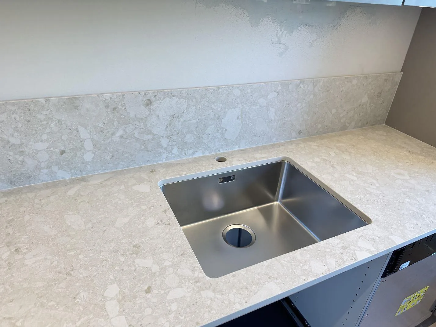 Köksbänkskiva i matt Dekton Ava, keramik, med rostfri diskho och matchande stänkskydd i ett kök i Mölndal.
