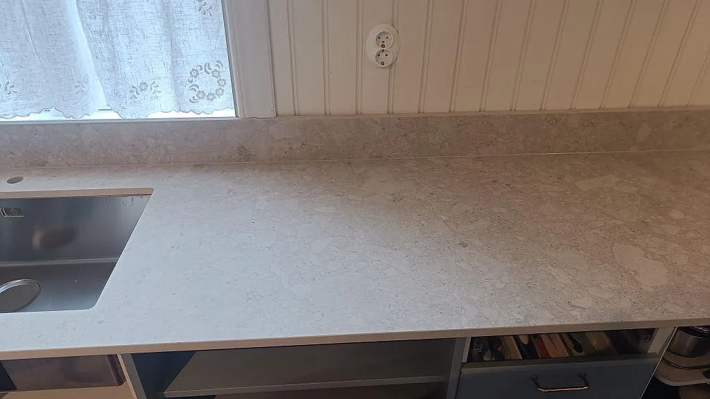 Rak bild av arbetsyta i matt Dekton Ava, keramik, med stänkkant och diskhozon i Nässjö.