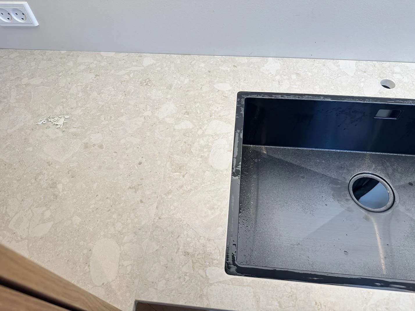 Närbild på matt Dekton Ava köksbänkskiva med mörk diskho och ljus stenlik spräckling i Værløse.