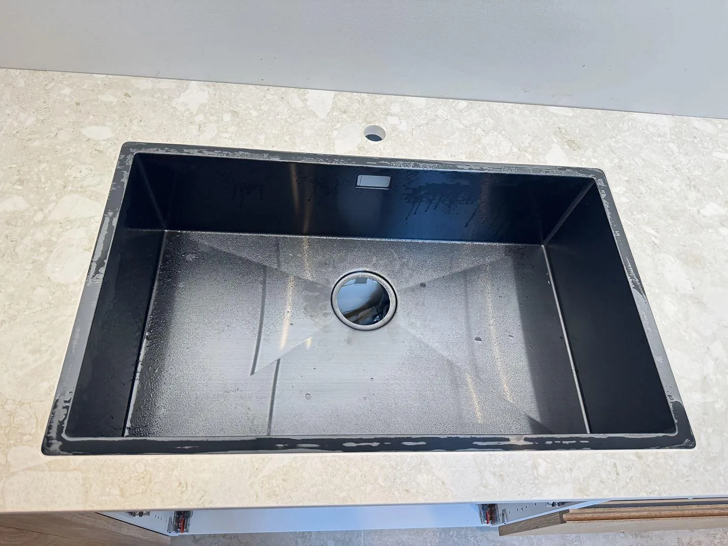Mörk diskho i en installerad köksbänkskiva av matt Dekton Ava, ljus keramik, i Værløse.
