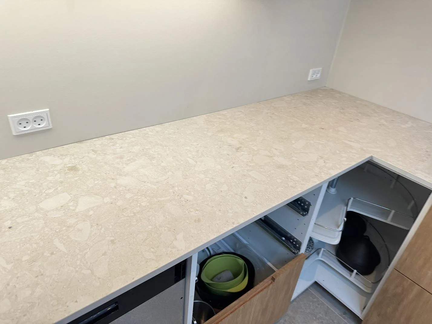L-formad arbetsyta i matt Dekton Ava med öppen träinredning och hörnpassning i ett kök i Værløse.