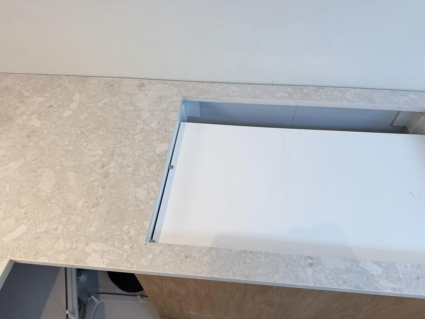Matt Dekton Ava köksbänkskiva med rektangulär öppning och ljus spräcklig keramikyta under montering i Værløse.