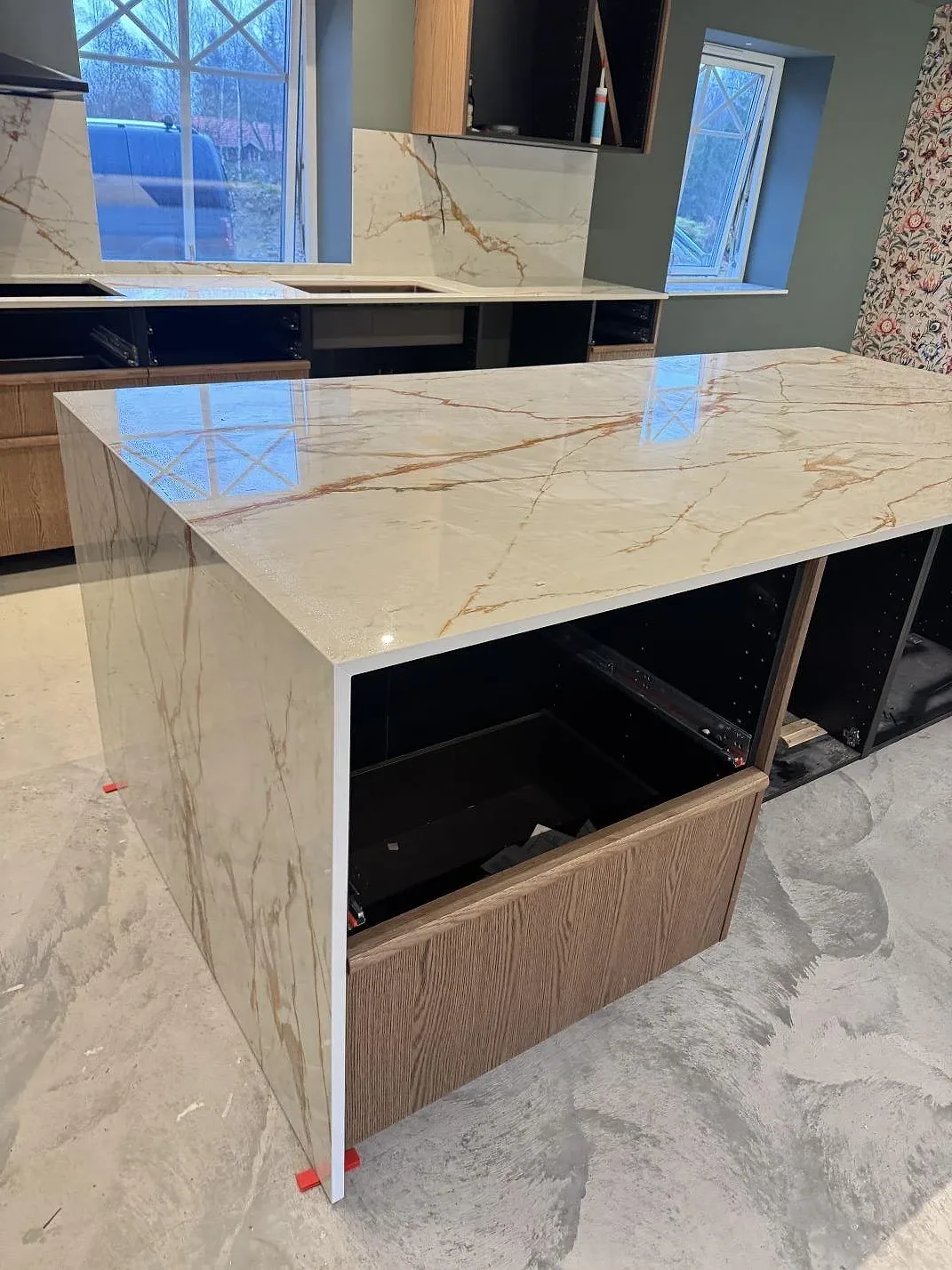 Polerad Dekton Awake på köksö och väggbänk, ljus keramik med speglande yta och stänkskydd i Osby.