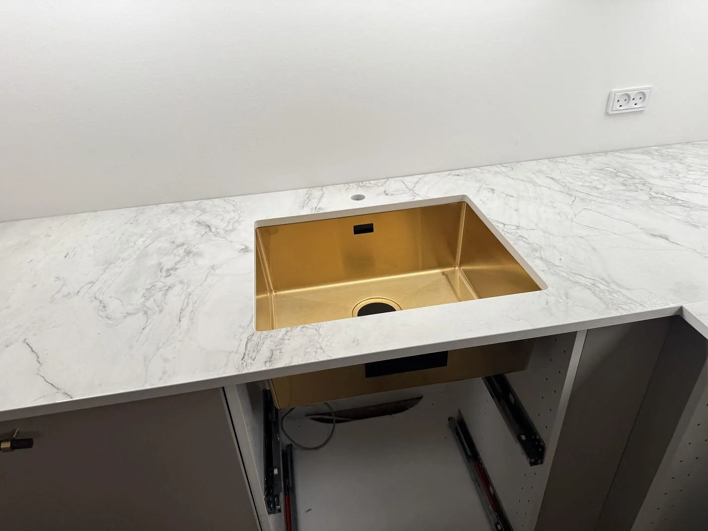 Köksbänkskiva i polerad Dekton Bergen med synlig mässingsfärgad diskho och grå ådring i Frederiksberg.