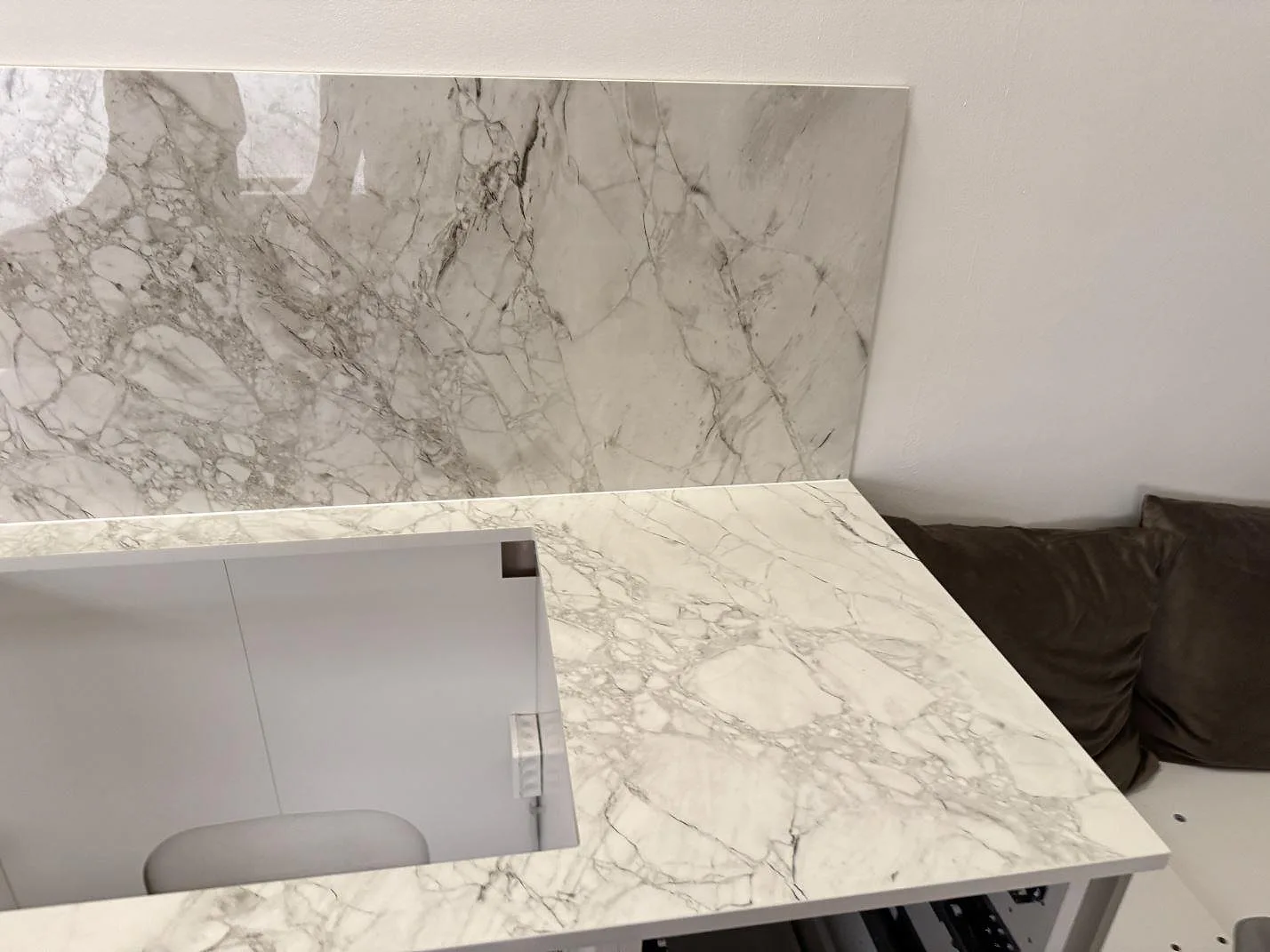 Höger del av polerad Dekton Bergen bänkskiva med väggbeklädnad och grå ådring i Frederiksberg.