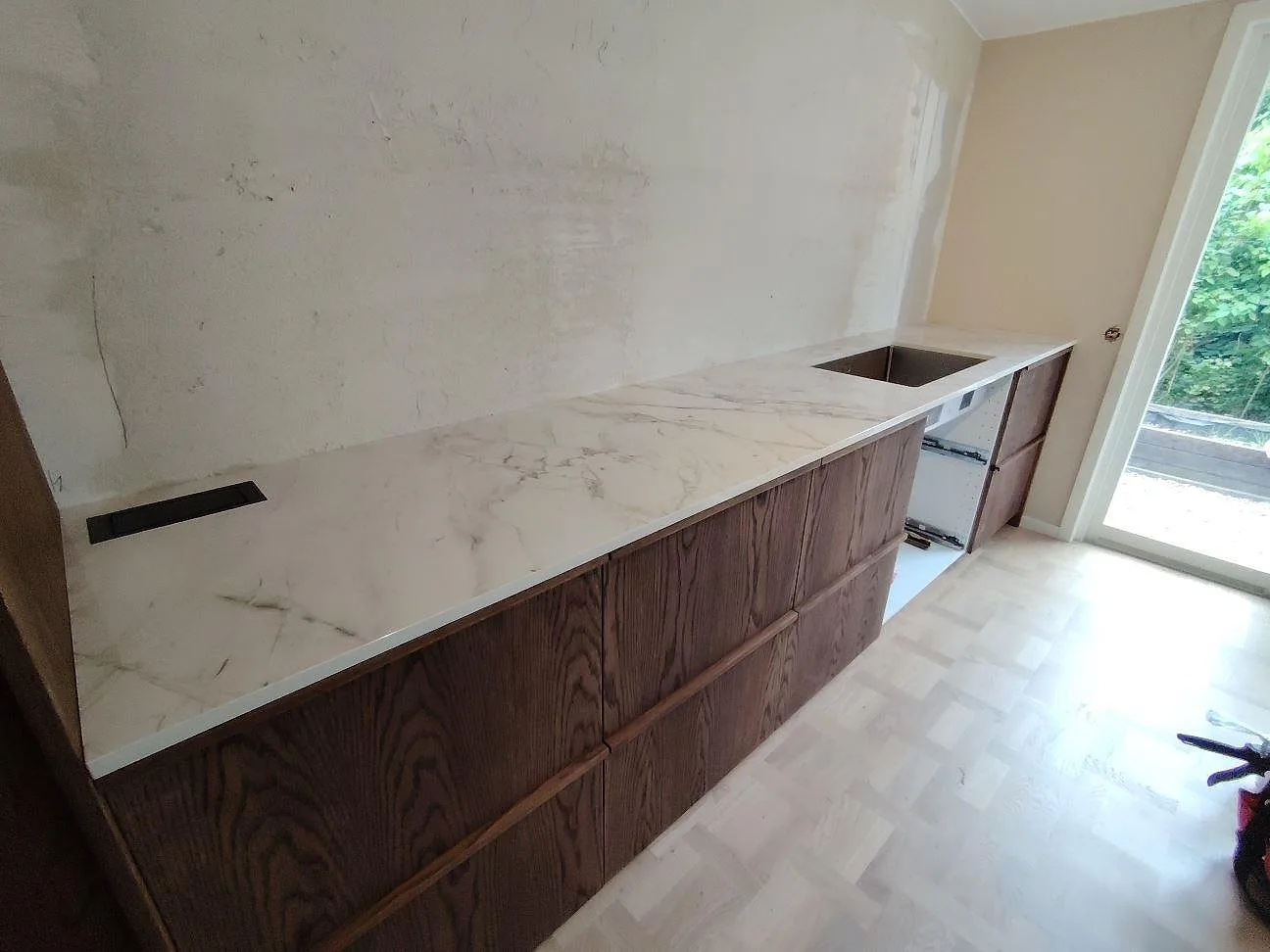 Närbild av polerad Dekton Bergen som keramisk köksbänkskiva med grå ådring på bakre bänk i Saltsjö Boo.