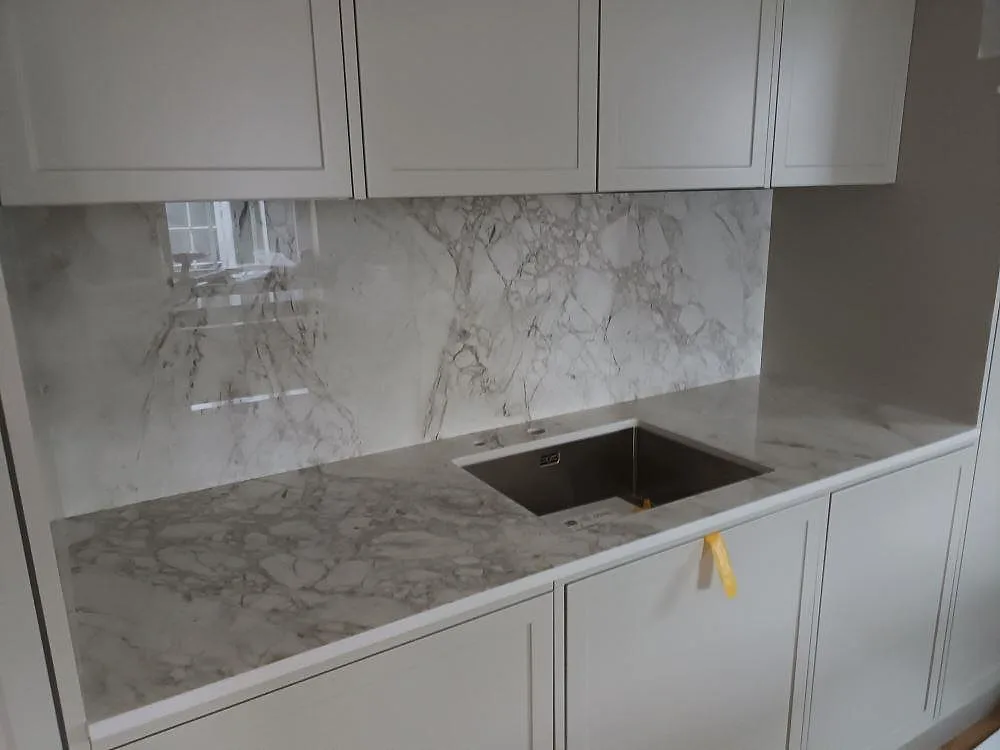 Köksbänkskiva i Dekton Bergen, polerad keramik, med heltäckande stänkvägg och underlimmad diskho i ett kök i Trångsund.