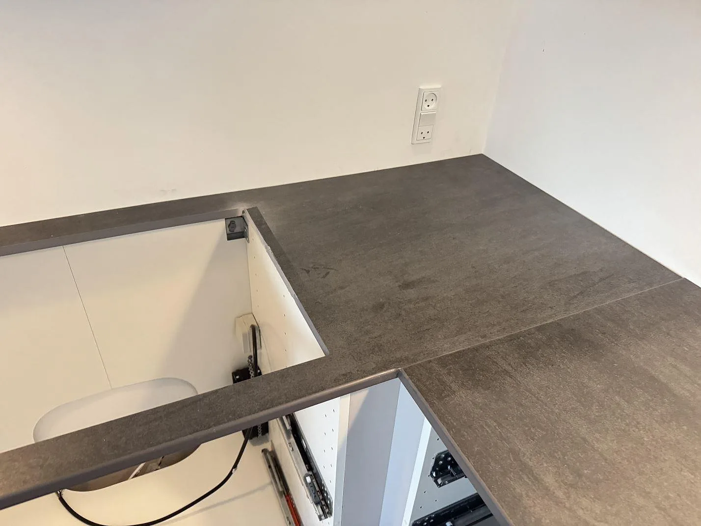 Mörkgrå matt Dekton Bromo på köksbänk med hällurtag och vägguttag under montering i 3500 Værløse.