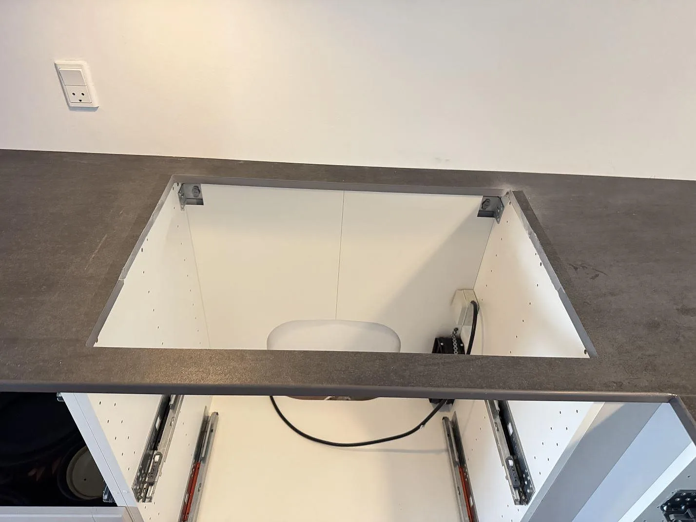 Hällurtag i matt Dekton Bromo med synlig mörk kant och köksstommar under installation i 3500 Værløse.
