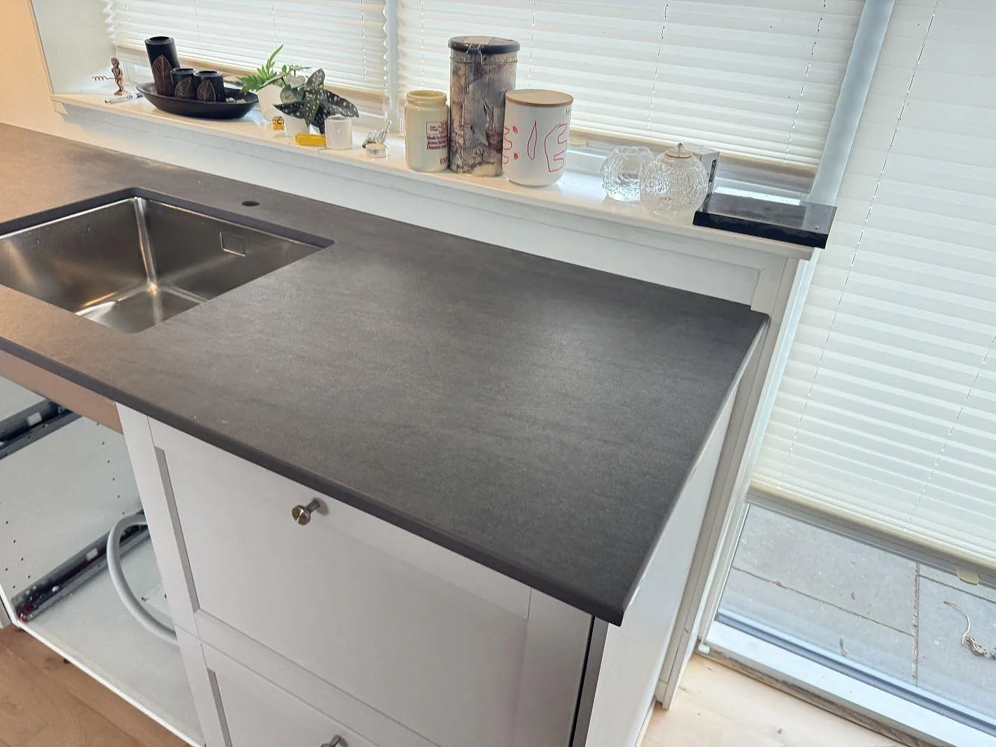 Detalj av matt Dekton Bromo som köksbänkskiva med diskho, blandarhål och fönsterparti i 3500 Værløse.