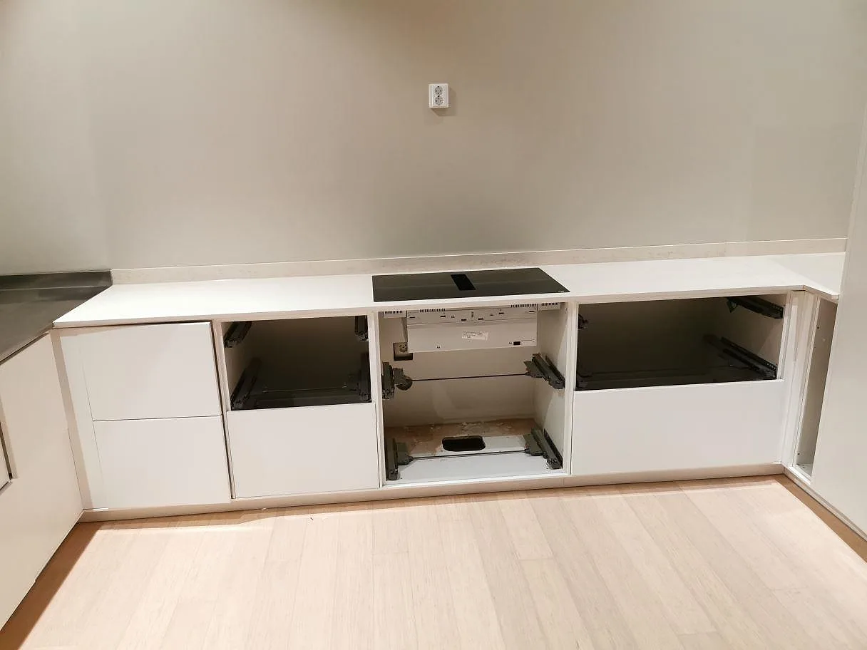 Köksbänkskiva i Dekton Danae, matt beige keramik med kalkstensliknande ådring, med planmonterad induktionshäll i ett kök i Åhus.