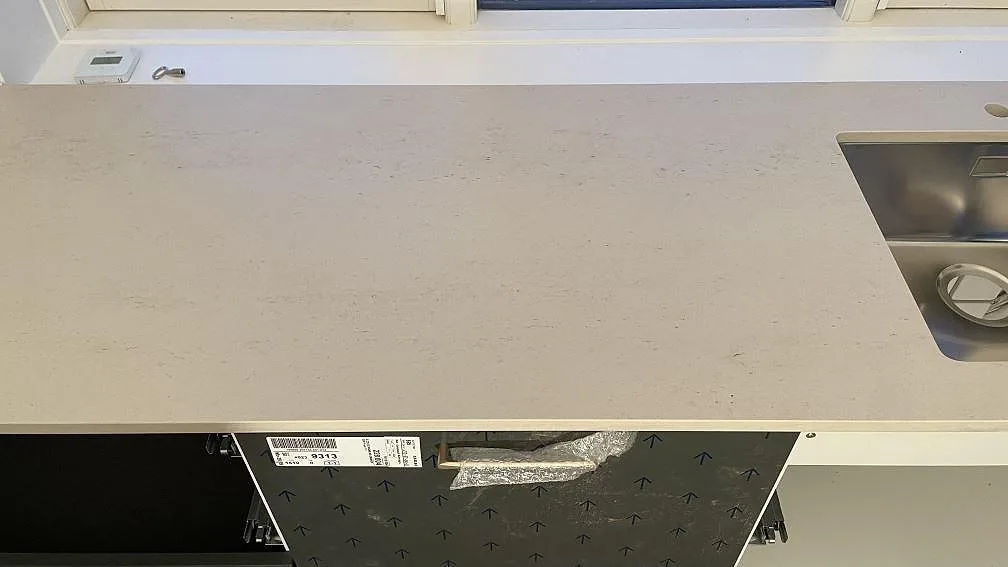 Matt Dekton Danae bänkskiva med rostfri diskho i den långa köksraden under fönstret i Gentofte.