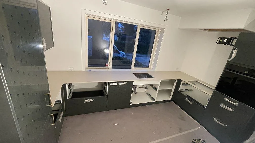 Köksbänkskiva i matt Dekton Danae, 20 mm, monterad i L-form vid fönster och högskåp i ett kök i Gentofte.