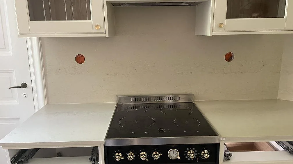 Rak vy mot spisen med ljus matt Dekton Danae som bänkskiva och väggbeklädnad mellan underskåp och överskåp i Göteborg.
