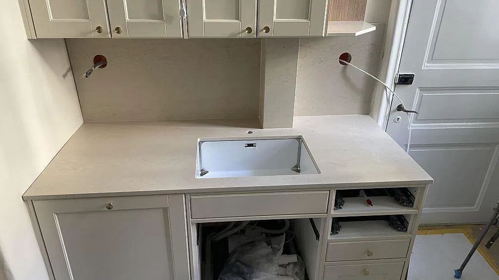 Diskbänkssida i ett kök i Göteborg med matt Dekton Danae keramik, synlig diskho, kranhål och stänkskydd i samma material.