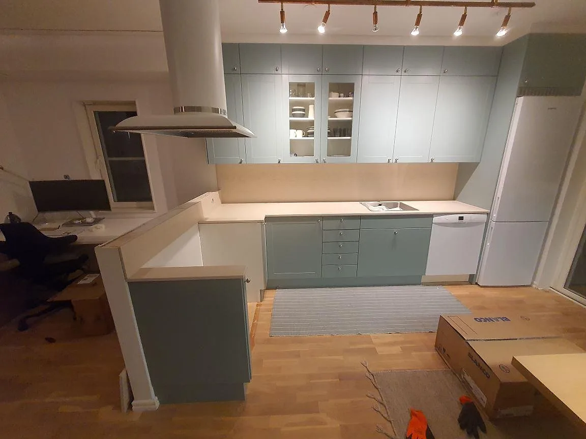 Köksbänkskiva i ljusgrå Dekton Danae, matt, med underlimmad diskho och uppvikt stänkkant i ett kök i Gustavsberg.