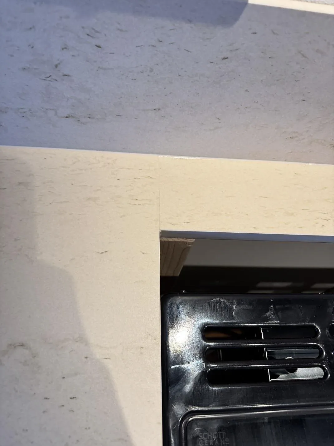 Ytdetalj av matt Dekton Danae keramik vid svart häll och ljus stänkkant i köket i Hakenäset.