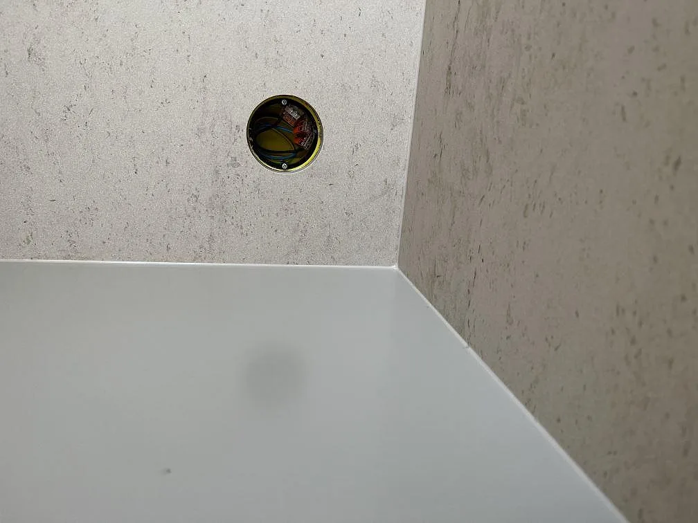 Fönsterbänk och bänkyta i ljus Dekton Danae, matt keramik, med urtag för eluttag i ett kök i Höllviken.