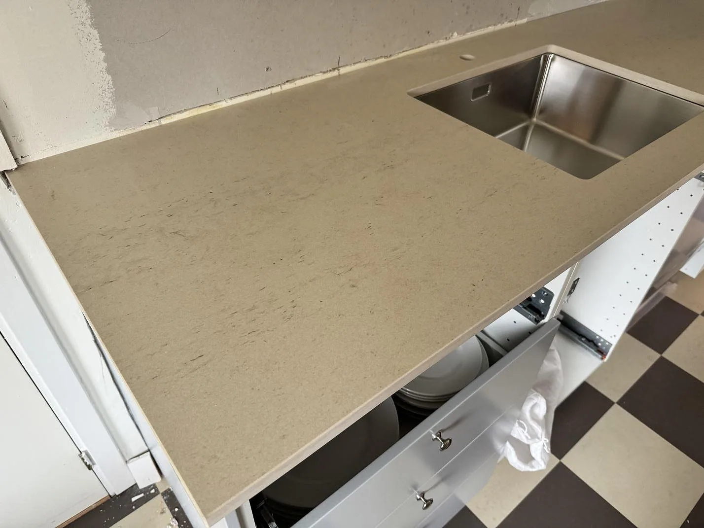 Närbild av matt Dekton Danae runt rostfri underlimmad diskho i ett kök under montering i Höör.