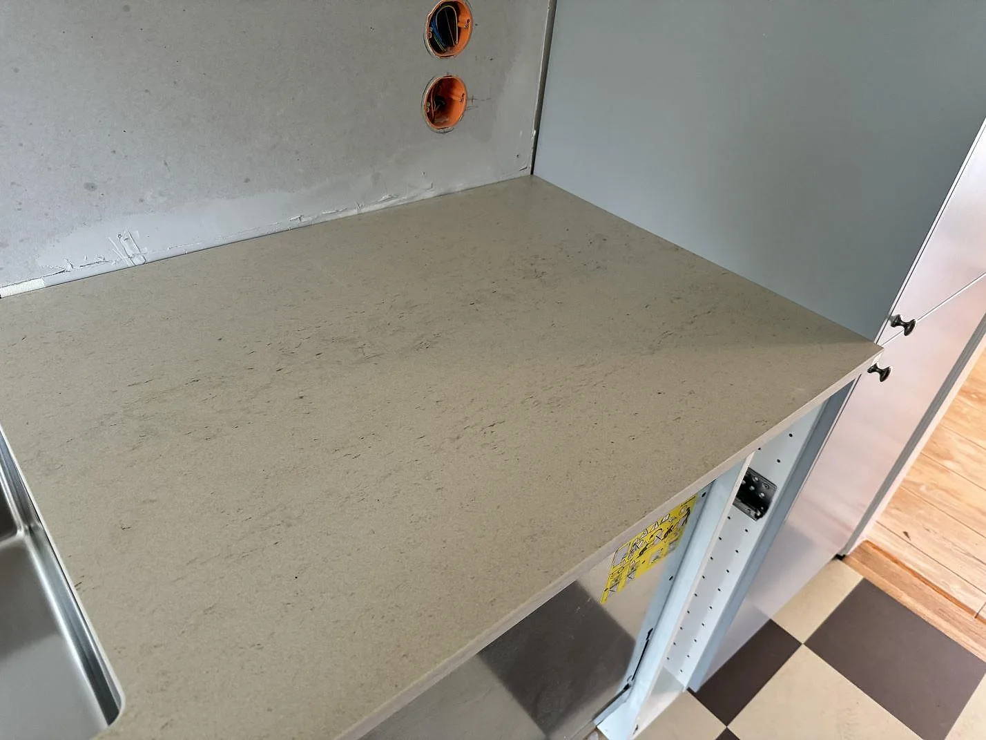 Detalj av matt Dekton Danae vid diskbänkens hörn, med synlig ådring och öppna stommar i Höör.