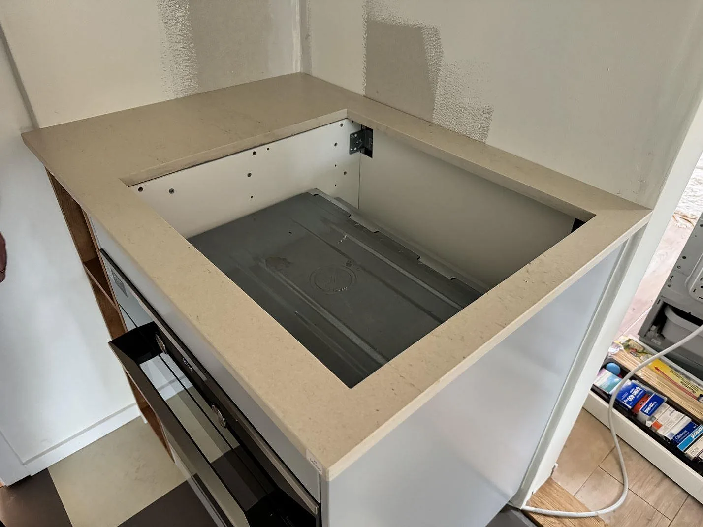 Köksö i matt Dekton Danae med öppning för häll och ljusa stommar i ett kök i Höör.
