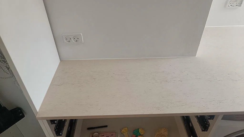 Närbild av matt Dekton Danae köksbänkskiva i keramik längs väggen, med låg stänkkant och öppna stommar i København N.