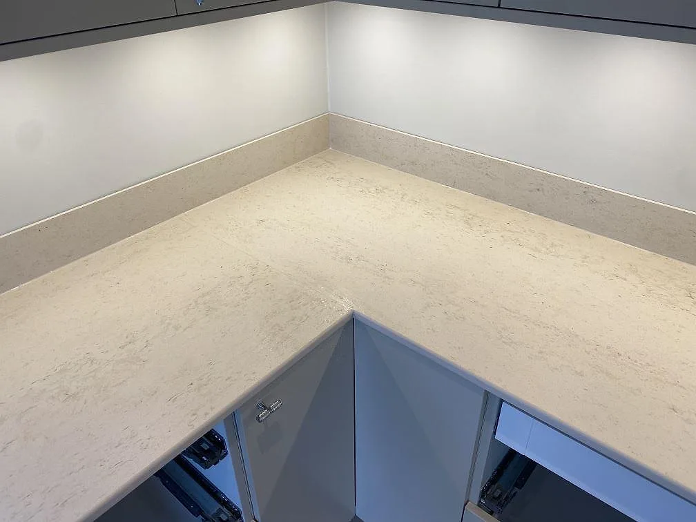 Hörnparti med matt Dekton Danae köksbänkskiva och låg stänkkant under överskåp i Lerum.