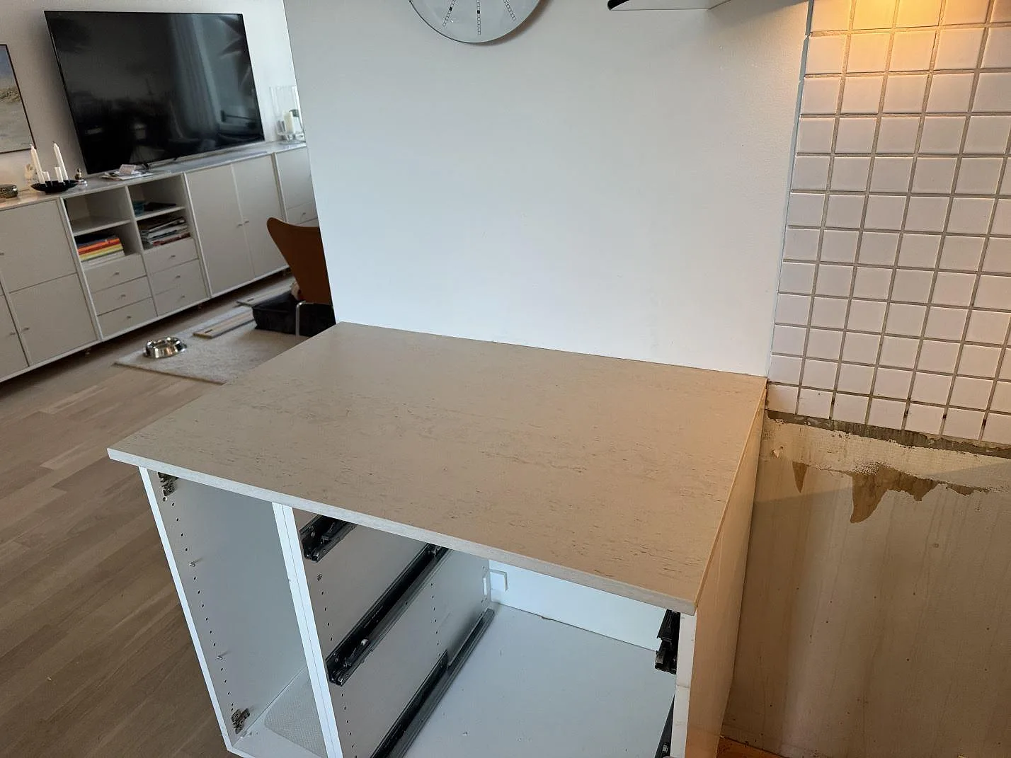 Köksbänkskiva i matt Dekton Danae, ljus keramik, på en skivyta över öppna köksstommar i Limhamn.