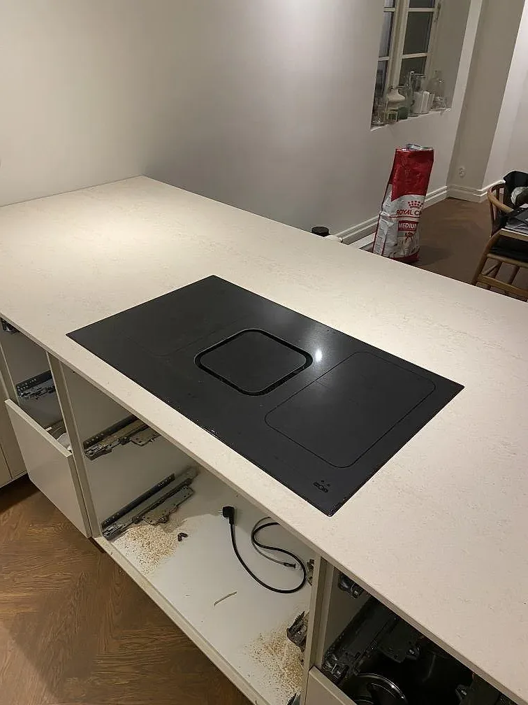 Infälld induktionshäll i matt Dekton Danae köksbänkskiva, varm greigeton, i ett kök i Lomma.