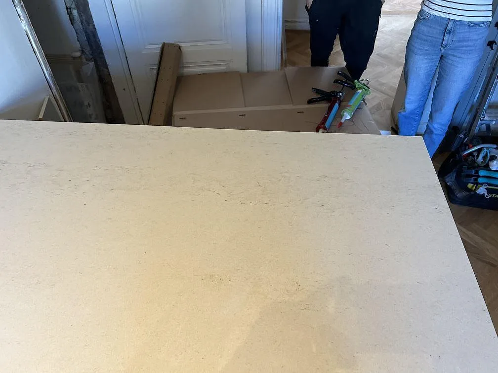 Närbild på den ljusa köksön i matt Dekton Danae med synlig ådring och monteringsverktyg i Malmö.