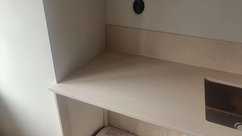 Sidovy av den matta Dekton Danae bänkskivan med varm ådring och lågt stänkskydd i Malmö.
