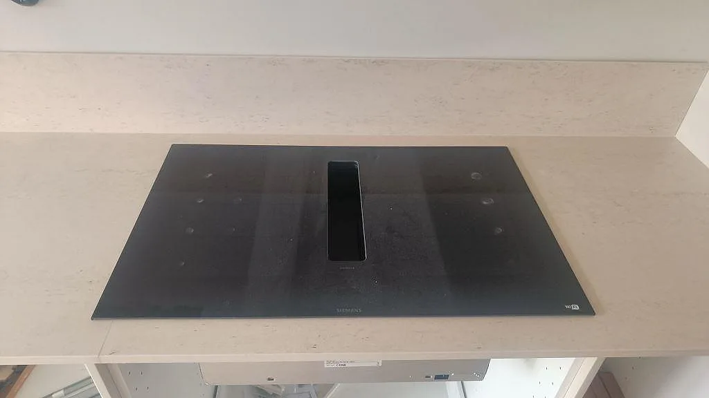 Svart häll på en ljus matt Dekton Danae köksbänkskiva med matchande stänkskydd i Malmö.
